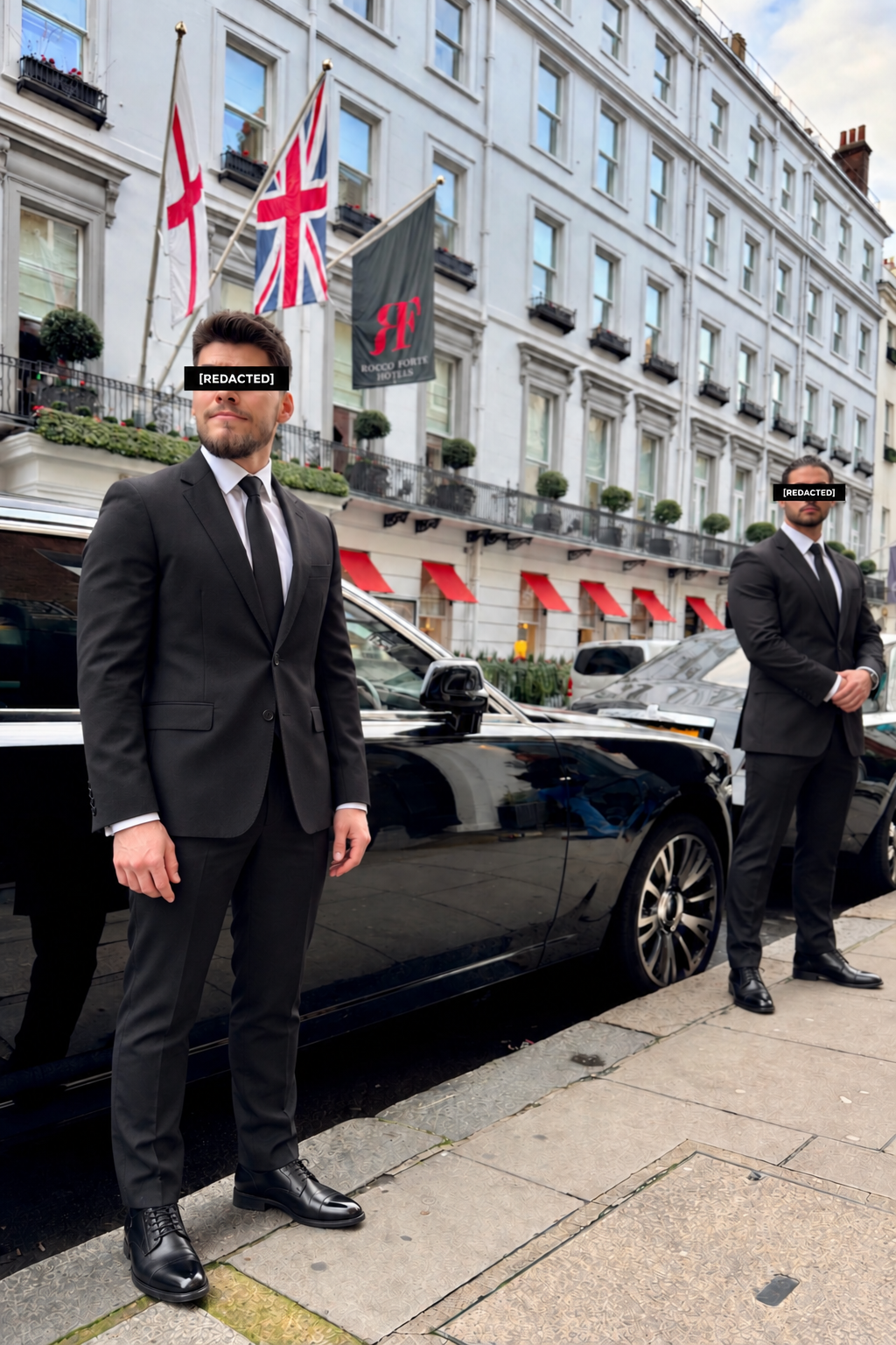 Discreet close protection operatives beside an executive vehicle